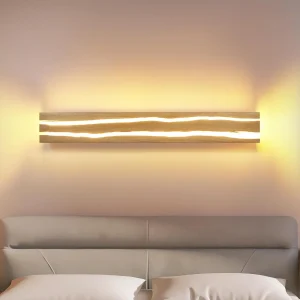 Applique murale bois horizontale éclairée au-dessus d’un lit
